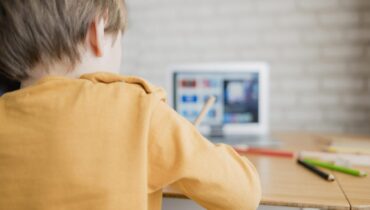 vista-posterior-nino-aprendiendo-computadora-portatil-casa